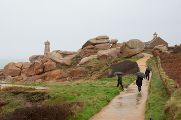 Des personnes sous la pluie en hiver - Côte de granit rose -Bretagne France