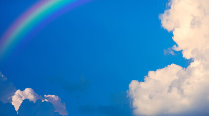 abstract blue sky background; rainbow and clouds - 745788816