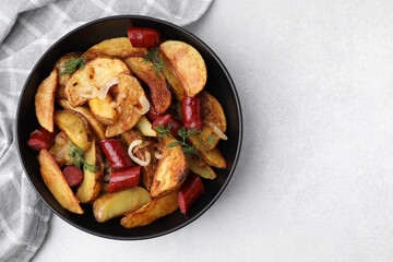 Delicious baked potato with thin dry smoked sausages, onion and dill in bowl on gray table, top view. Space for text