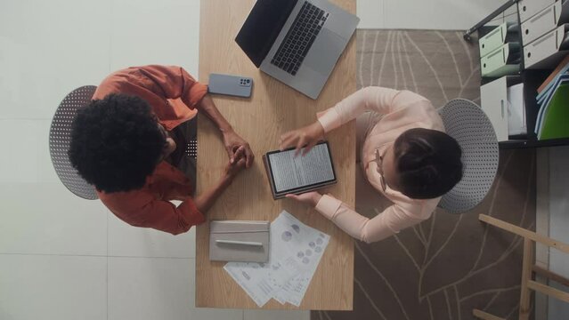 Zoom out directly above view of HR manager greeting male candidate at job interview