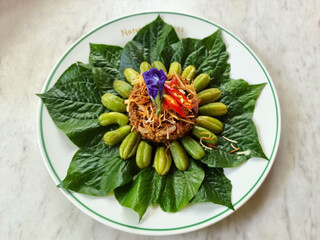 The Leaf-wrapped Bilimbi salad (Miang kham) on a white plate, Thai appetizer