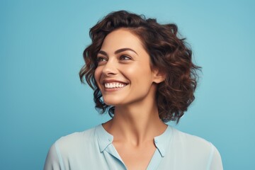 Portrait of happy smiling beautiful young business woman, over blue background
