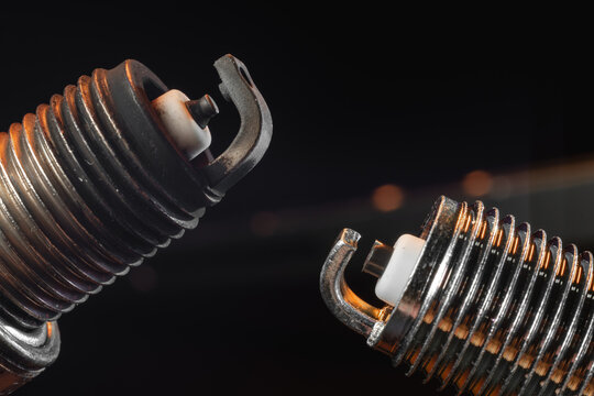 Close view. Automotive new and used spark plugs for gasoline engines. Nickel electrode, insulator. The concept of car service, repair. On a black background.