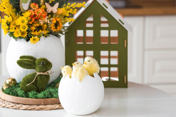 A spring bouquet, yellow little chickens in a large egg and Easter eggs with a golden pattern on...