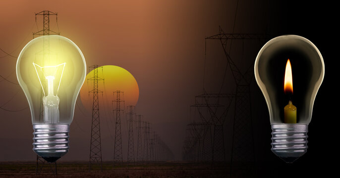 A light bulb with a burning candle inside and an ordinary light bulb against a background of a sunset sky and power lines stretching into the distance. Emergency blackout concept.