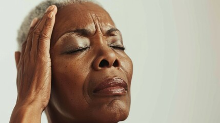 A woman with closed eyes her hand on her forehead appearing to be in deep thought or distress. - 745802890