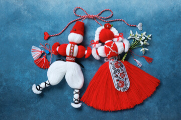 Red and white symbol of the holiday March 1 Martenitsa, figures of a boy and a girl with bouquet of...