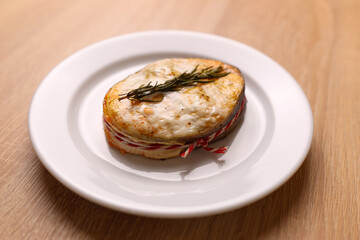 A freshly baked piece of salmon is placed on a plate and sauce is added