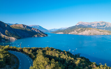Fototapeta premium Aerial photography by drone of the Serre-Ponçon lake and its mountains, located in the Hautes-Alpes in France