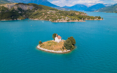 Aerial photography by drone of the Saint-Michel chapel on the Serre-Ponçon lake and its mountains,...