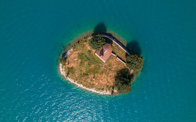 Aerial photography by drone of the Saint-Michel chapel on the Serre-Ponçon lake and its mountains, located in the Hautes-Alpes in France