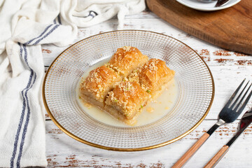 Baklava with milk. Milk baklava with hazelnuts on a white background. Local name sütlü nuriye baklava