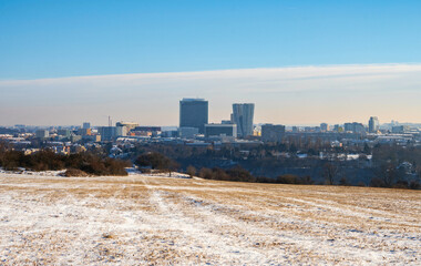 Snowy meadow and high buidling of Prague in winter. - 745813072