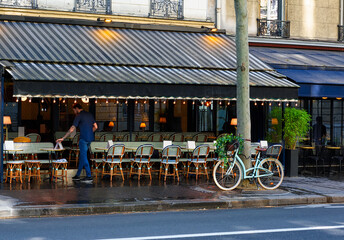 Cozy street with tables of cafe and vintage bicycle in Paris, France. Cityscape of Paris. Architecture and landmarks of Paris - 745816464