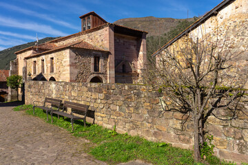 Church of the beautiful village of Carmona with mountain typical stone houses in a sunny day. Cantabria, Spain.