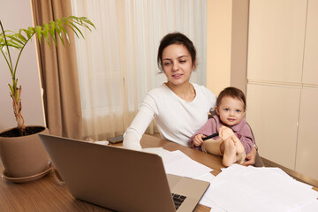 beautiful businesswoman working at home with her little child daughter. Stay at home