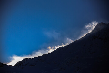 Obraz premium strong winds at the snowy mountain ridge above Saas-Fee
