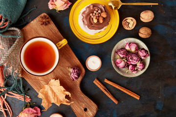 Obraz na płótnie Canvas Aesthetic Pavlova cake, Tea Cup. Autumn aesthetics tea time vibes flat lay among dry roses, leaves, blueberry, walnuts