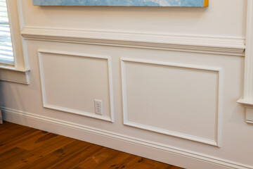 Cream colored architrave decorative wall molding wall trim with skirting and panels in the interior of an old home house - obrazy, fototapety, plakaty