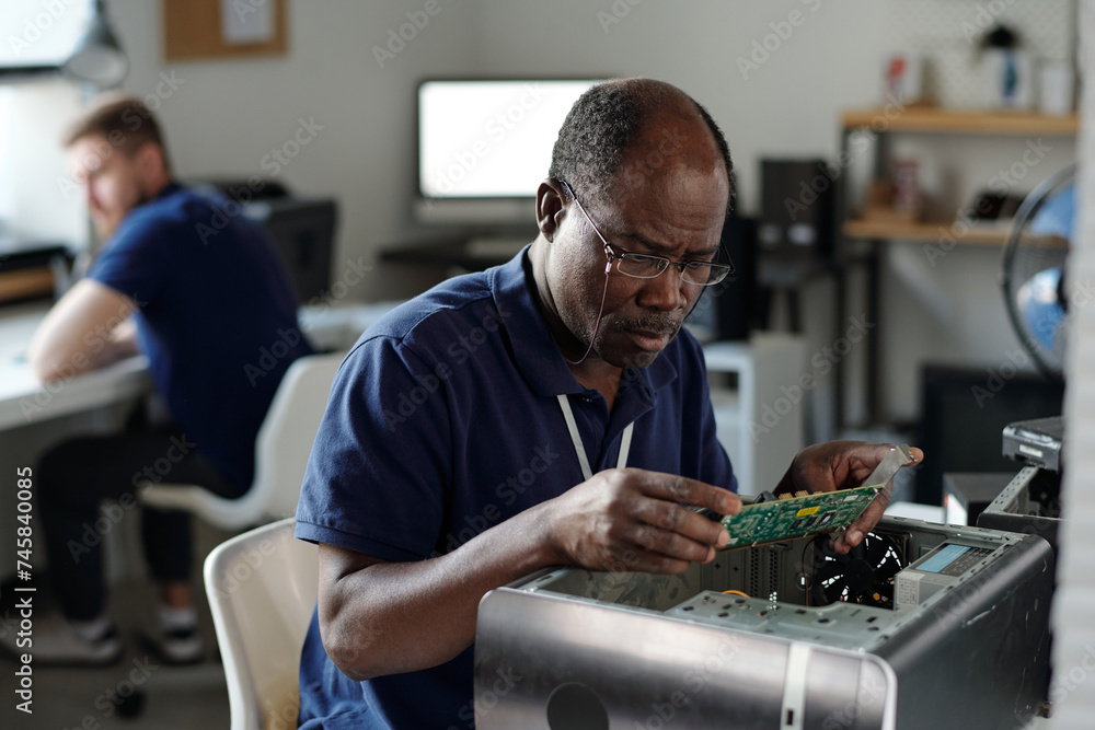 Aufkleber experienced african american repairman in eyeglasses looking at computer motherboard and identifying