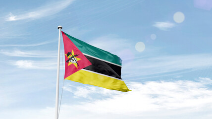 Mozambique national flag cloth fabric waving on the sky.