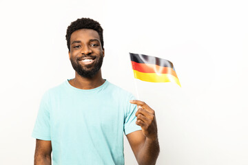 Portrait of a smiling African American man proudly holding a German flag, isolated on a white background, conveying a sense of national pride, diversity, and inclusivity. - 745842856