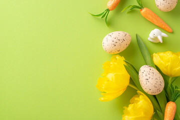 Bright Easter scene. Top view snapshot of eggs, carrots for the bunny, and tulips arrayed on a...