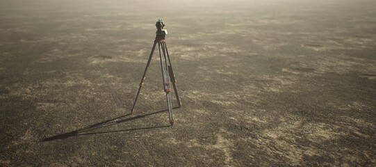 Land surveyor on tripod standing on wide open flat landscape.