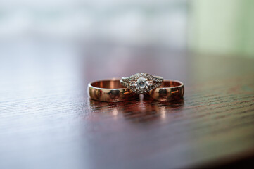 A pair of gold wedding rings on a brown background. Wedding rings on wooden background