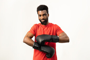 Portrait of a confident African American man wearing boxing gloves, ready for training. Isolated on white, this image conveys determination, strength, and a healthy lifestyle. - 745849840