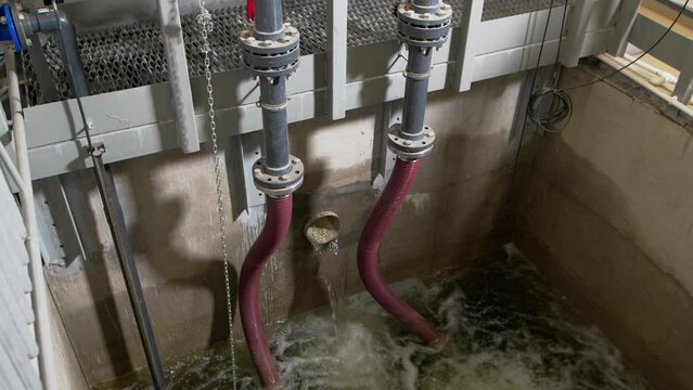 Running stream of wastewater flows into settler basin closeup. Stage of wastewater treatment with special equipment in industrial enterprise