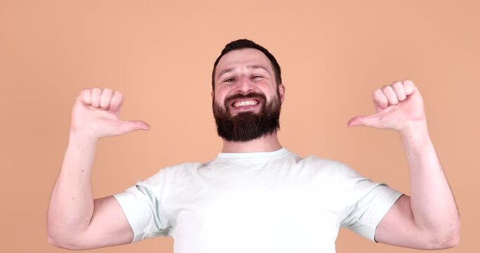 Excited bearded man pointing at self isolated on beige background. Pick me concept.
