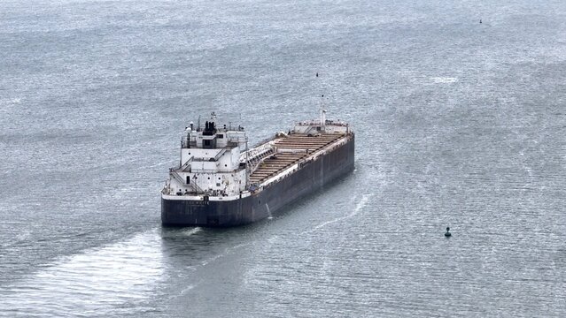 Container ship traveling on Lake Erie under cloudy skies with calm water - Powered by Adobe