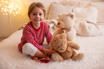 Cute preschool boy, playing with white and red bracelets. Martenitsa, white and red strains of...