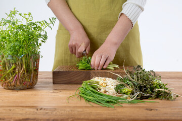 원목 테이블 위 봄 야채들을 손질하고있는 손