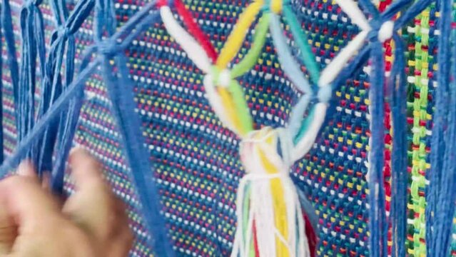 Woman's hands weaving hammock, blue color, handmade cotton fabric.