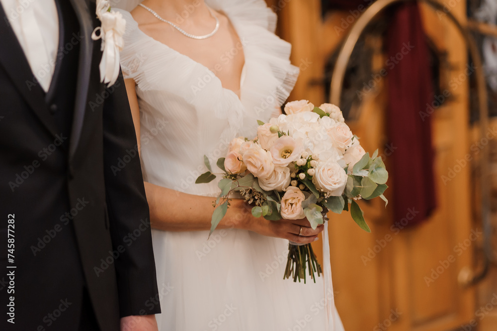 Wall mural A beautiful wedding bouquet in the hands of the bride. Bouquet with white flowers in the hands of the bride