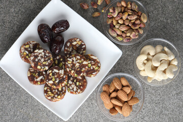 Healthy snacks, fitness lifestyle and high fiber diet concept with dates and dryfruits energy bars surrounded by dried fruits, Cashew Nuts, pistachios , almonds