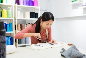 Woman choose the color of thread for making of tufting carpet at studio