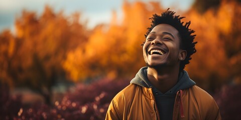 Man Delightedly Laughing Against a Background of Colorful Autumn Foliage. Concept Autumn Photoshoot, Joyful Portraits, Colorful Background, Candid Laughing Portrait