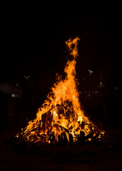 Large bonfires are lit at night as part of popular and ancestral celebrations in the squares of villages and cities from the Mediterranean. Texture of a wood fire, low key photography