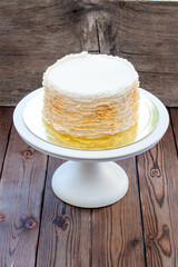 Golden and white fondant ruffle cake on rustic wooden background