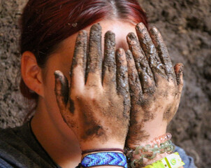 person with muddy hands