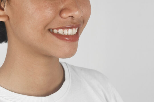 Close up of a woman toothy smile on white background.