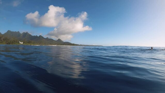 horizontal view of look out to the pacific horizon to two scuba divers floating on top the calm ocean sea water surface in Avana passage harbor in the afternoon sunset with blue sky no clouds sunshine