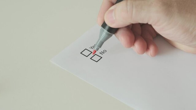 Man hand putting mark on no in checkbox on paper blank, close-up, slow motion
