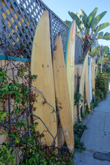 California ocean side street with a fence decorated with surfing boards