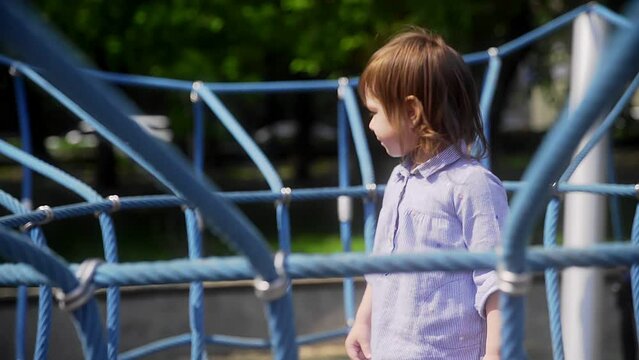 A little girl jumps on a trampoline in the playground