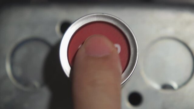 Pushing red emergency stop button with index finger