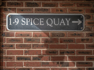 Sign on brick wall indicating direction to Spice Quay, Old Portsmouth, UK.